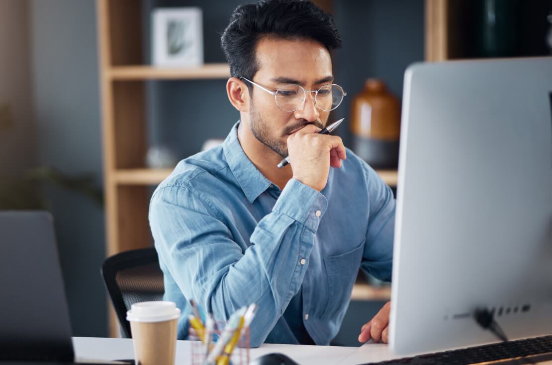 Serious, business man and thinking on computer in office, internet research and website. Focused male employee, desktop and solution of ideas, planning decision and review strategy, project or vision